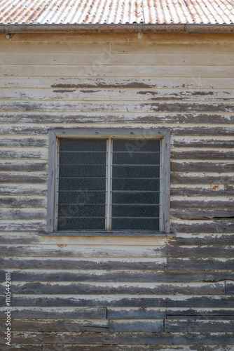 Old abandoned timber house and window, faded peeling paint, derelict building wall, ghost town photo