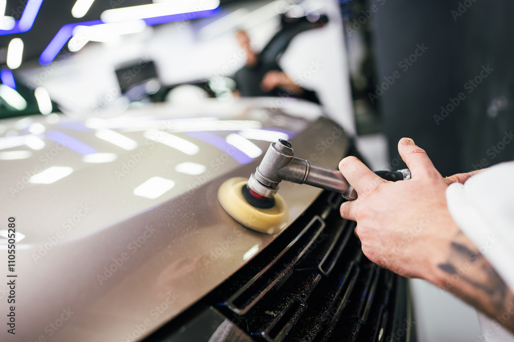 Professional vehicle polishing and detailing service in a modern car workshop. Brightly lit workspace with large led lights. High quality car valeting concept. Professional vehicle polishing and detailing service in a modern car workshop. Brightly lit workspace with large led lights. High quality car valeting concept.