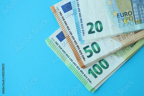 Big amount of one hundred, twenty and fifty euro money bills on blue background photo