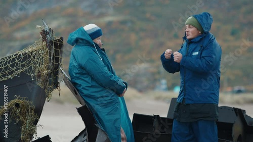 Young fisherman communicates with elderly woman and vividly tells a story about his resent fishing photo