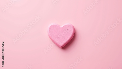 Single heart-shaped pink marshmallow on pink background for Valentine's Day concept