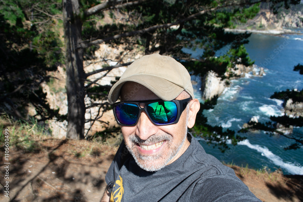 a 50 year old man with sunglasses on a mountain by the sea on the coast of Chile a 50 year old man with sunglasses on a mountain by the sea on the coast of Chile