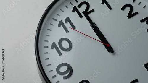 Round clock shows one minute to twelve, close-up. Classic clock time and New Year or New Day