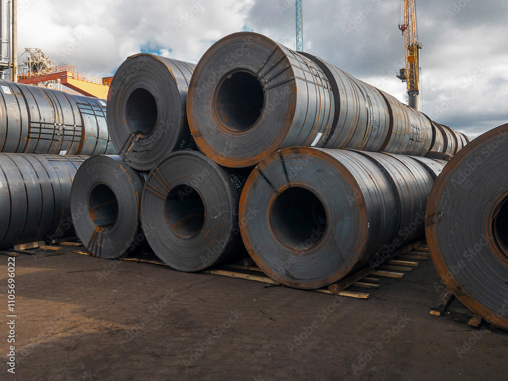 Sheet metal in the port. Steel rolls. A roll of sheet iron. Hot rolled steel rolls are stored outdoors. Steel rolls are available in stock.Rolls of steel sheet. Sheet metal in the port. Steel rolls. A roll of sheet iron. Hot rolled steel rolls are stored outdoors. Steel rolls are available in stock.Rolls of steel sheet.