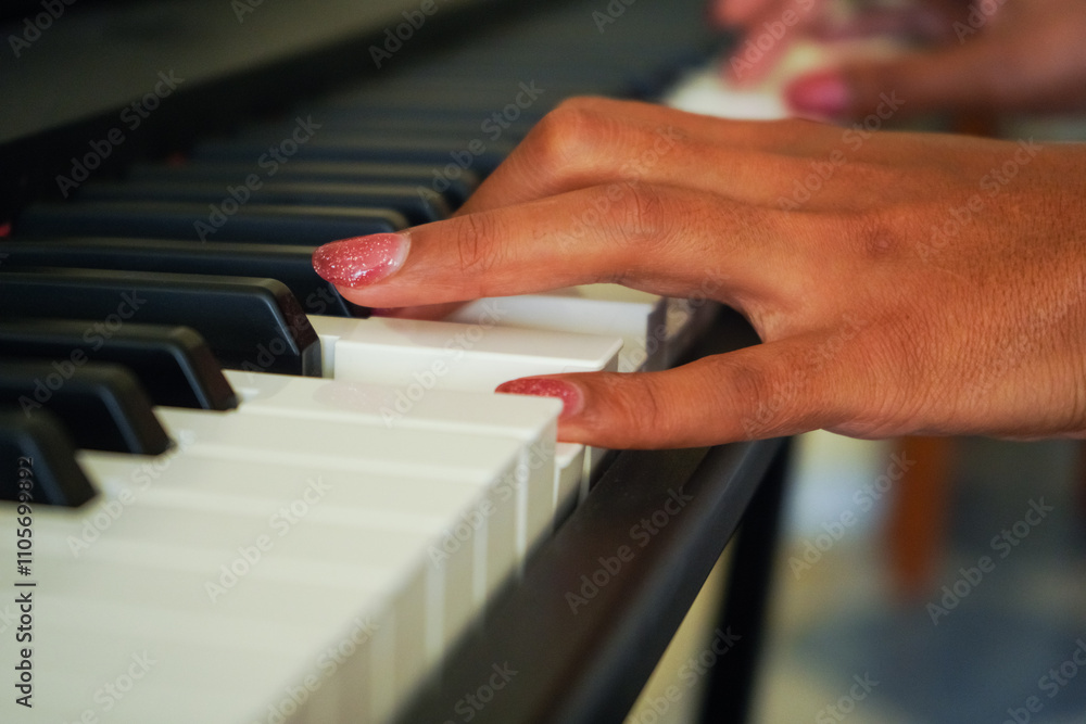 Fototapeta premium Woman Hand with Manicure Playing Digital Synthesizer Indoor. Close-Up Shot.