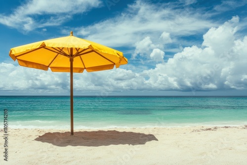 Yellow umbrella provides shade on sandy beach near turquoise ocean and vibrant clouds