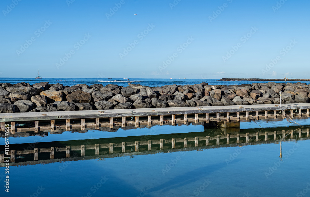 Harbor Pier Silhouetted in the Clear Blue Water at Waikiki, Hawaii. Harbor Pier Silhouetted in the Clear Blue Water at Waikiki, Hawaii.