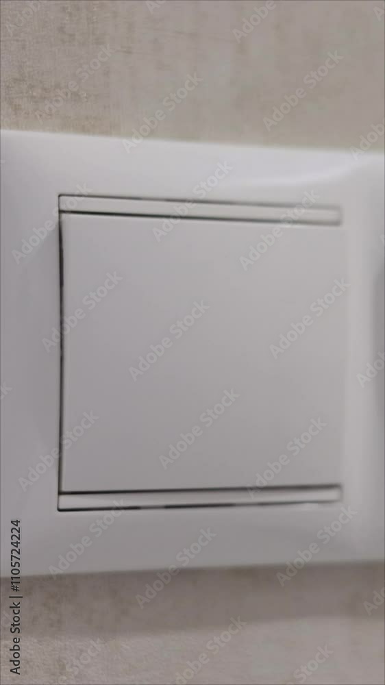 Close-Up Of A Hand Turning On A Light Using A Modern White Switch Panel. Concept Of Energy Efficiency And Home Lighting Control. Vertical. Close-Up Of A Hand Turning On A Light Using A Modern White Switch Panel. Concept Of Energy Efficiency And Home Lighting Control. Vertical.