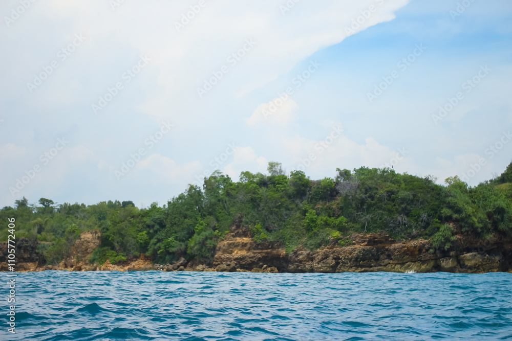 Long sea view with white cliff island with trees in the distance seen from the sea. Long sea view with white cliff island with trees in the distance seen from the sea.