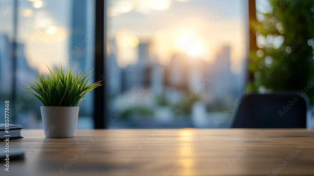 Modern office workspace with a plant and city skyline during sunset Modern office workspace with a plant and city skyline during sunset