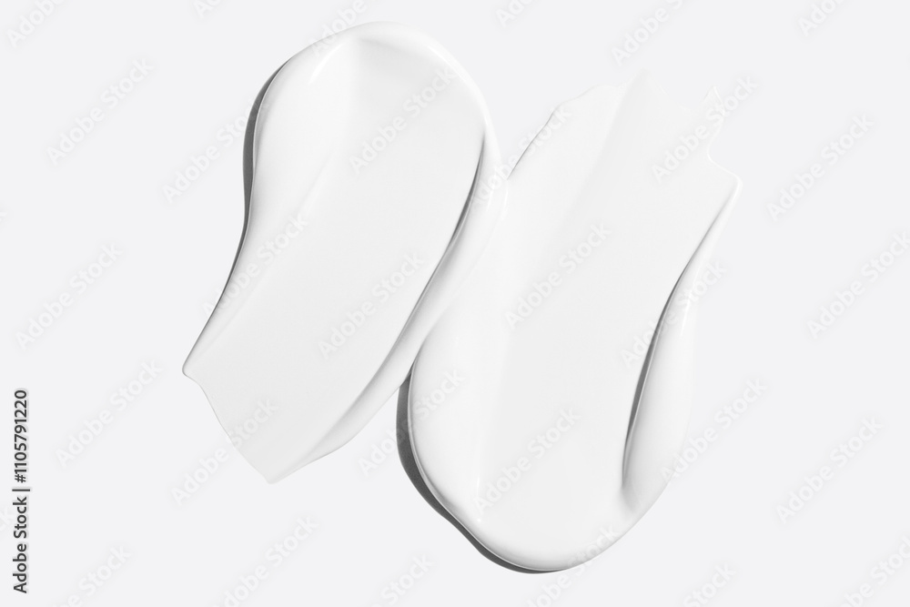Smears of white cosmetic cream on a light background Smears of white cosmetic cream on a light background