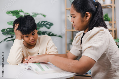 The boy is stressed from studying, Sister helping boy writing lesson and learning to write, Education home school concept.