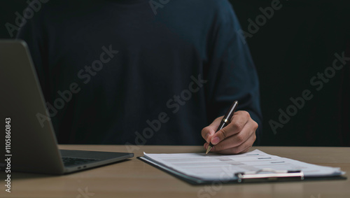Obraz na płótnie A person reviews and signs documents on a clipboard, document approval, verification, and professional decision-making in business or finance. w salonie