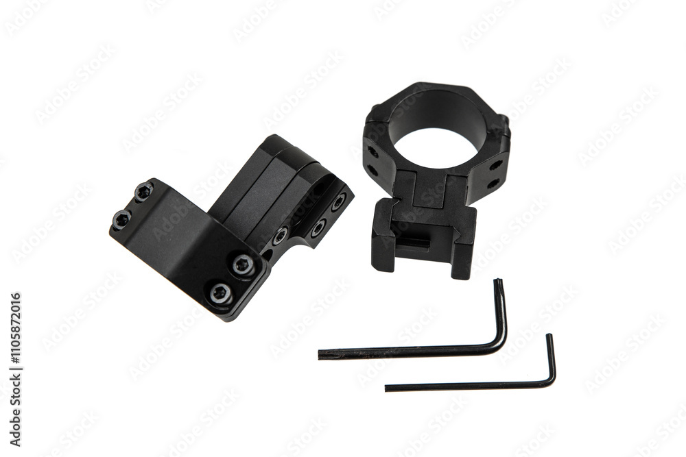 Obraz premium A pair of black scope rings with mounting hardware, including two hex keys, used for attaching a scope to a firearm, isolated on a white back
