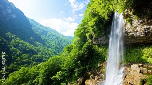 Majestic Waterfall Cascading Through Lush Green Mountain Landscape