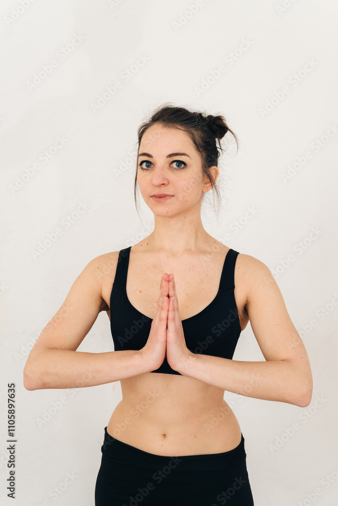 Obraz premium woman practices yoga with her arms folded across her chest