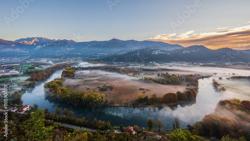 autumnal foggy morning sunrises over the Adda river, Lecco, Italy 