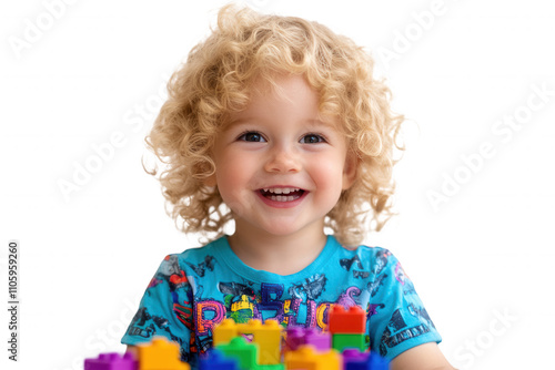 A cheerful young child with curly hair enjoys building with vibrant blocks, displaying a joyful expression. The setting is bright and minimalistic, focusing on the child's captivating smile and playfu photo