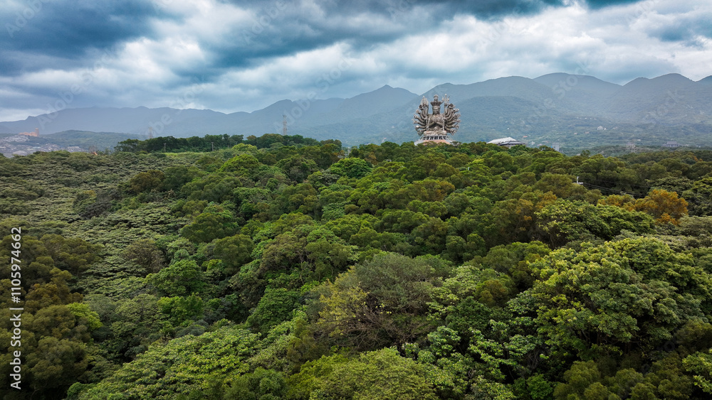 Holy Thousand Hand Guanyin statue overlooking lush greenery in Taiwan during cloudy weather Holy Thousand Hand Guanyin statue overlooking lush greenery in Taiwan during cloudy weather