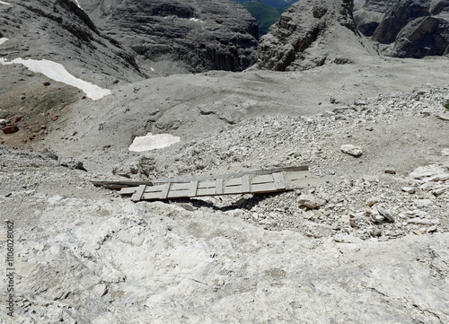 Unstable wooden bridge on a trail used to cross the scree and chasm towards the valley floor photo