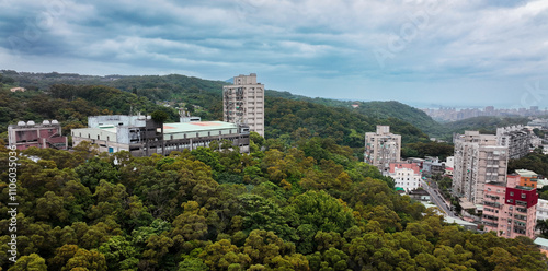 Aerial view of urban buildings surrounded by lush hills in Taiwan during cloudy weather