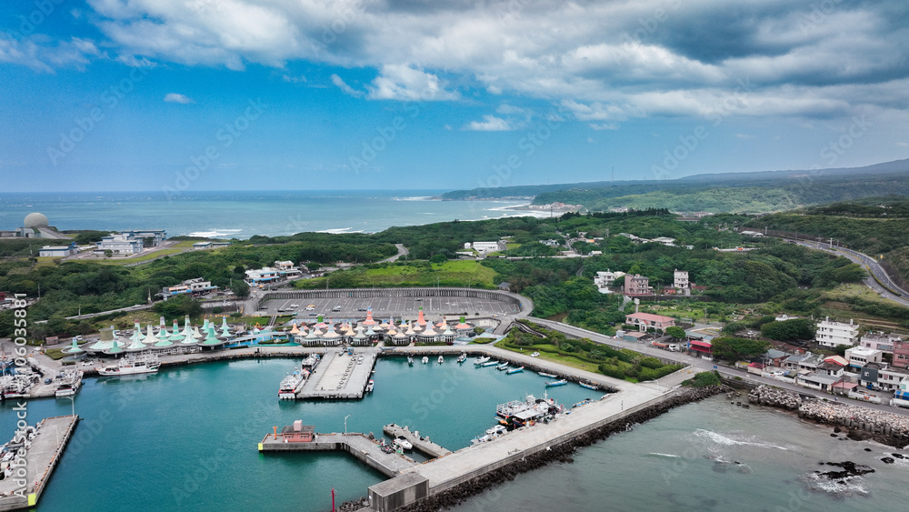 Aerial view of a vibrant harbor in Taiwan with boats and lush green hills in the background Aerial view of a vibrant harbor in Taiwan with boats and lush green hills in the background