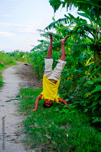 Photography Young rural boy playing outside, boy practicing tumbling in outdoor