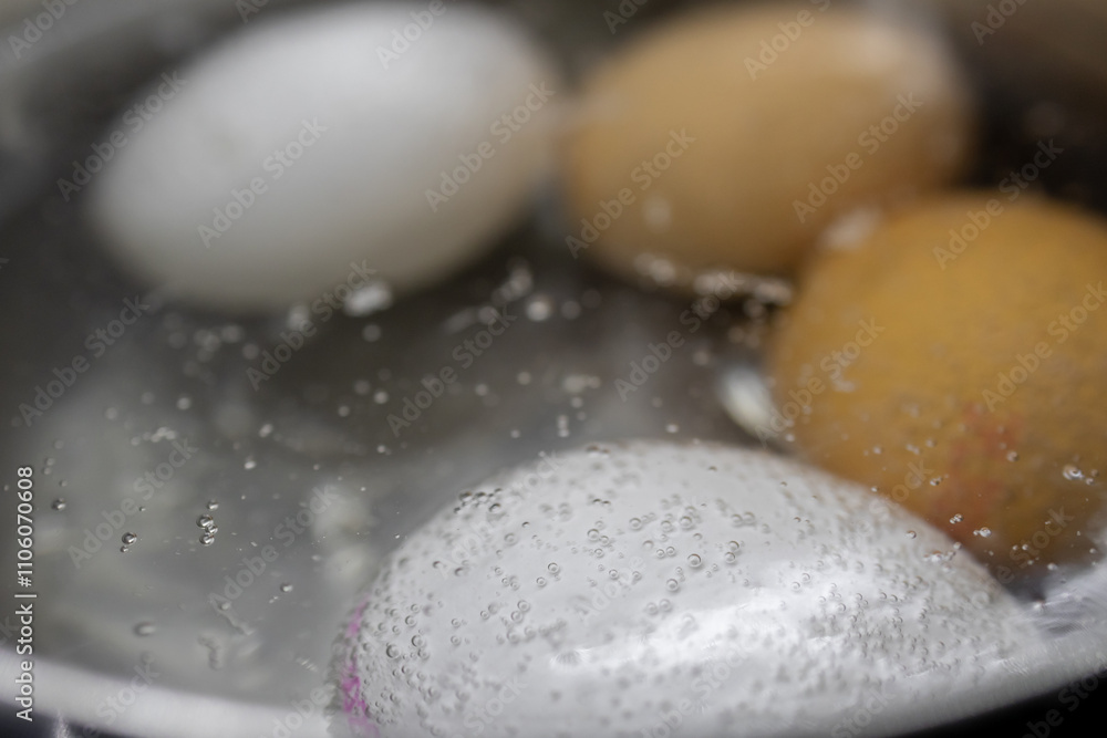 boiling eggs in water with visible bubbles, close-up macro view, focusing on texture and cooking process