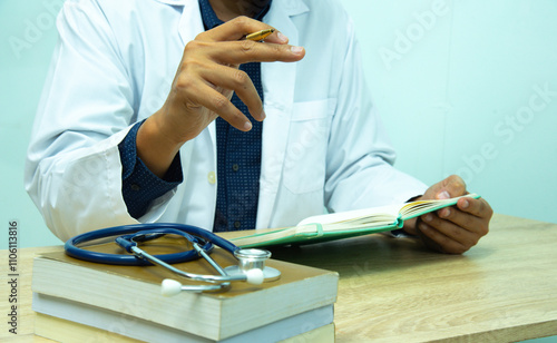 Doctor is documenting a patient's information. The physician, in the white medical coat is filling out a medical record form during a consultation in the clinic. photo