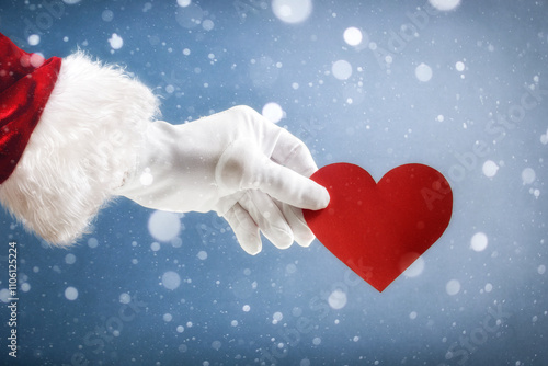 Santa Claus holding a heart cutout on snowy background