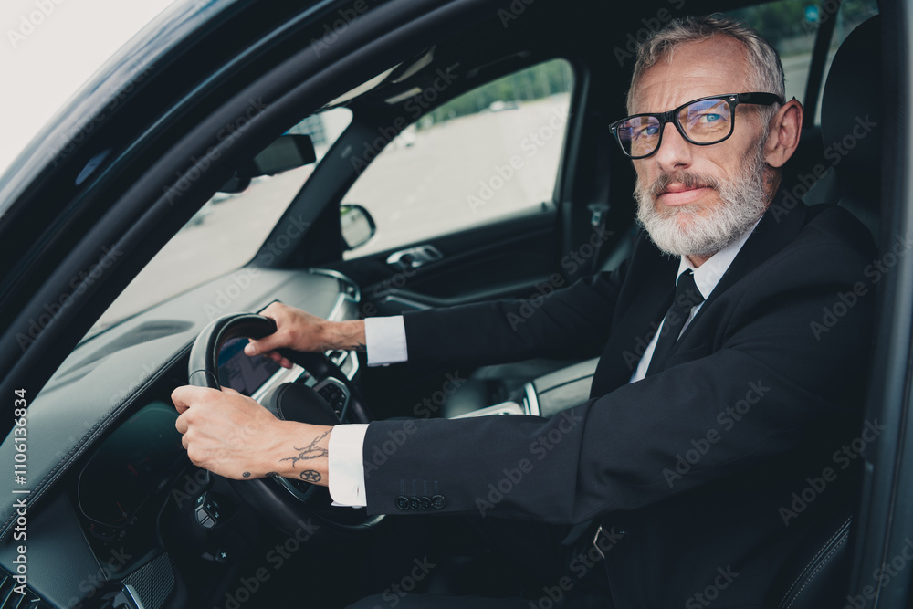 Experienced business professional driving modern car on city street, showcasing formal wear and confidence for travel and business meetings Experienced business professional driving modern car on city street, showcasing formal wear and confidence for travel and business meetings