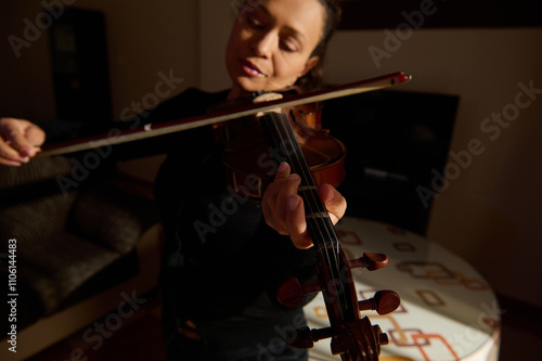 Close-up of woman playing violin in dimly lit room photo