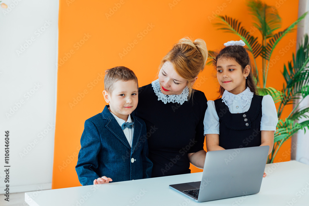 Fototapeta premium Teacher and boy with girl school children with laptop at school