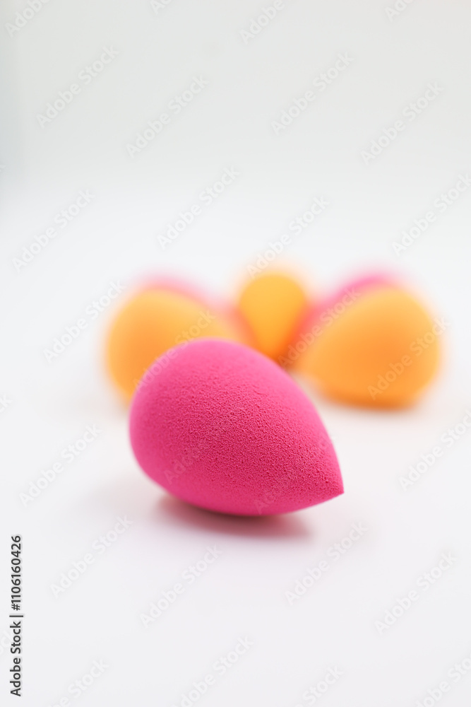 pink and orange Cosmetic sponges on light wooden background, close up pink and orange Cosmetic sponges on light wooden background, close up