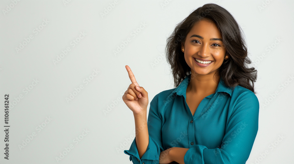 Image of a beautiful, smiling Indian woman posing and pointing her finger to the side. The image is blank, advertising, communication. Image of a beautiful, smiling Indian woman posing and pointing her finger to the side. The image is blank, advertising, communication.