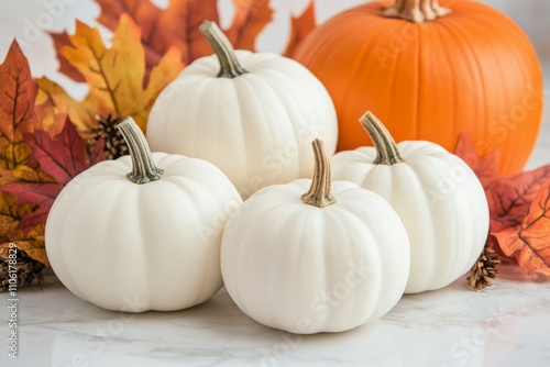 White pumpkins and autumn leaves arranged on countertop for seasonal decor