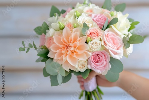 Beautiful floral bouquet featuring pink and cream roses with greenery for spe...