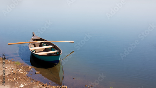 Rowing boat moored to the shore. Spring on the river. Floating.