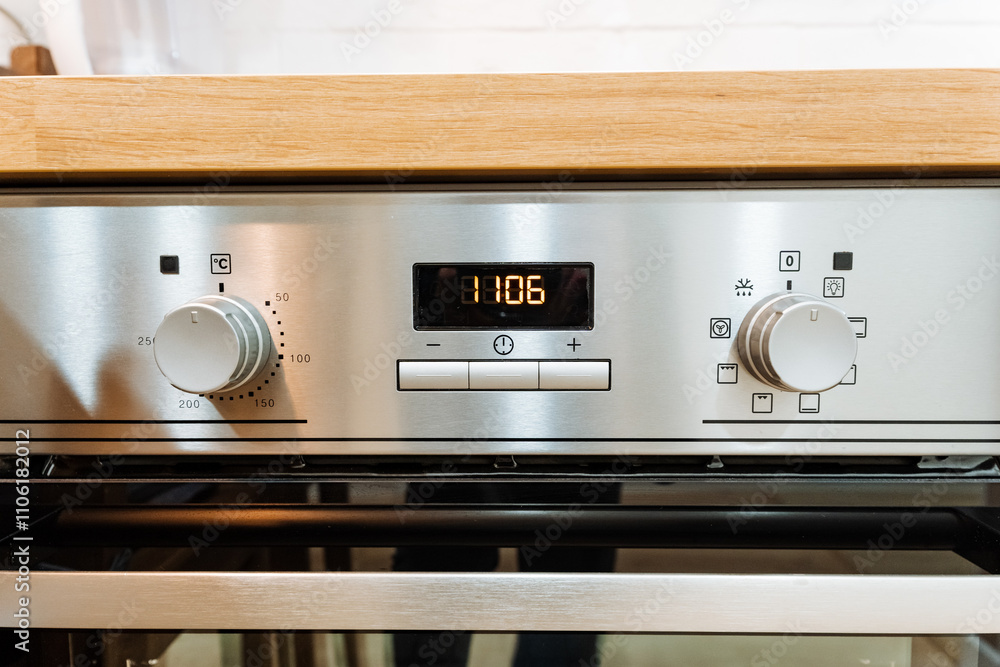 Obraz premium A sleek stainless steel oven is currently positioned on top of a polished wooden counter surface, indicating its role as an essential kitchen appliance in a home setting