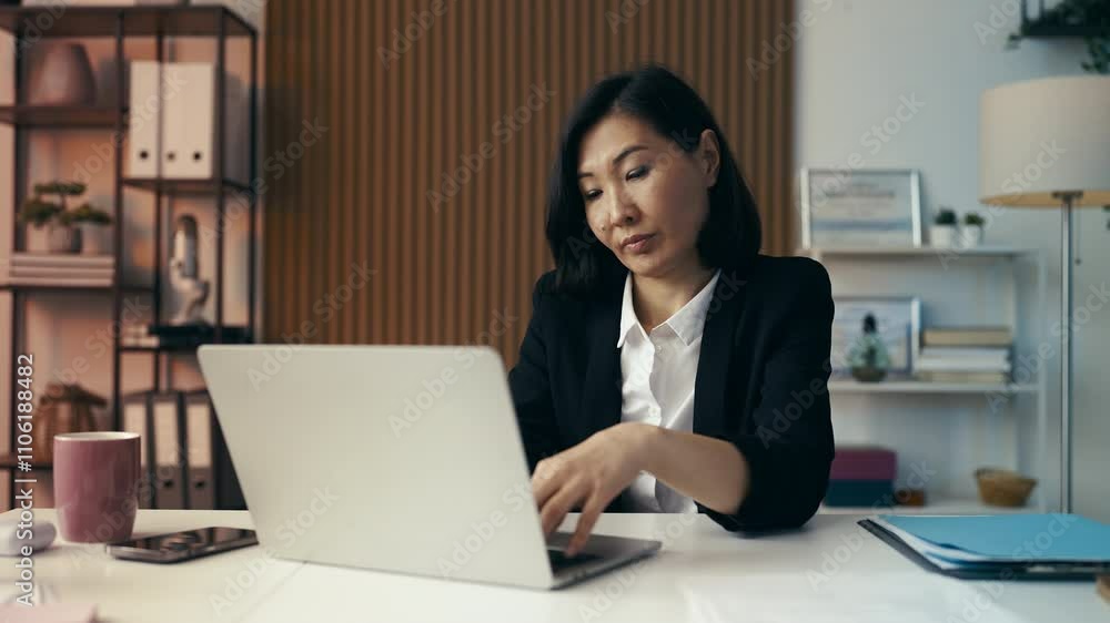 Asian woman suffers neck pain while working on her laptop, a sedentary lifestyle Asian woman suffers neck pain while working on her laptop, a sedentary lifestyle