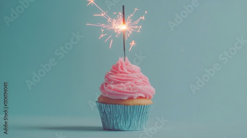 Sparkling cupcake with pink frosting on a blue background for celebration pur...