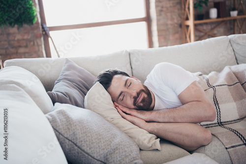 Photo of young man lying on soft comfy divan sleeping calm weekend indoors home room apartment photo