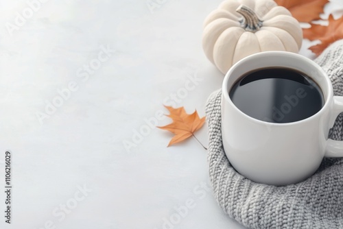 Warm coffee and a small pumpkin create a cozy autumn atmosphere on a chilly day