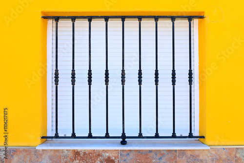 Yellow facade with window and wrought iron railing photo