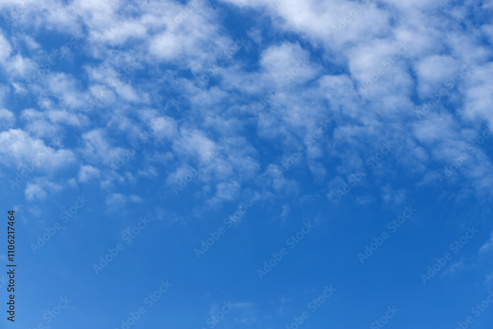 Blue sky with a few clouds background.