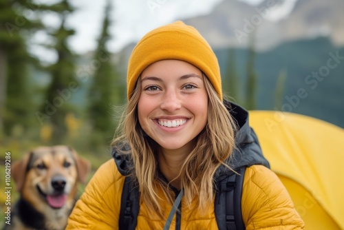 Smiling woman with dog in autumn forest during a sunny afternoon