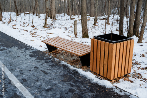 Wallpaper Mural A sturdy wooden bench, complemented by a trash can, sits quietly on the side of a snowcovered road, which together create a serene winter scene filled with immense beauty and tranquility Torontodigital.ca