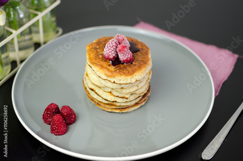 Stack of American pancakes with blueberry jam and fresh raspberries photo