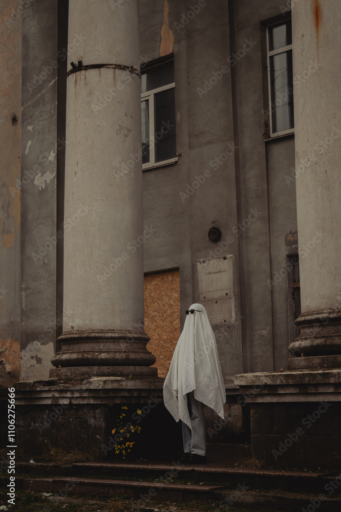 A figure draped in a ghostly white sheet stands before weathered gray columns of a crumbling building, surrounded by autumn leaves. The atmosphere feels eerie yet intriguing. A figure draped in a ghostly white sheet stands before weathered gray columns of a crumbling building, surrounded by autumn leaves. The atmosphere feels eerie yet intriguing.