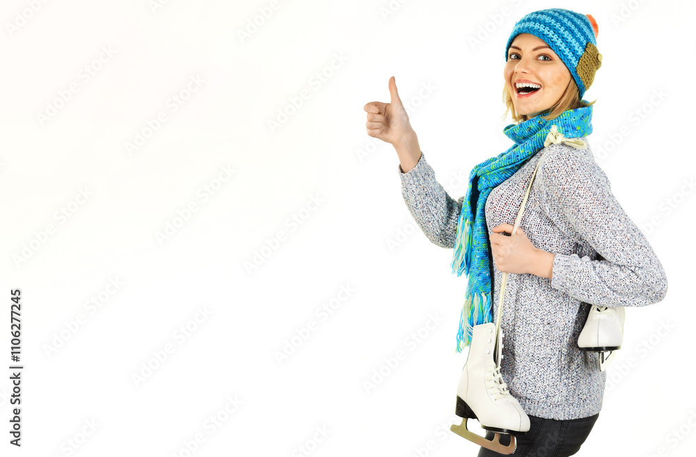 Happy woman in winter clothes with ice skates showing thumb up. Winter sport. Ice skating girl. Sporty woman in warm sweater, hat and scarf with skates for figure skating. Copy space for advertising. Happy woman in winter clothes with ice skates showing thumb up. Winter sport. Ice skating girl. Sporty woman in warm sweater, hat and scarf with skates for figure skating. Copy space for advertising.